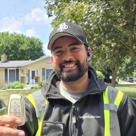 Alex, technician at Car Keys Geeks holding a car key on a mobile call